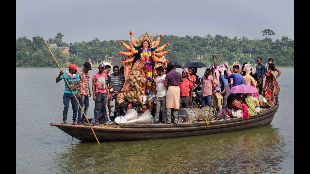 An idol of Goddess Durga being taken to puja pandal on a boat sailing over the Hooghly River in Nadia. Pic/PTI